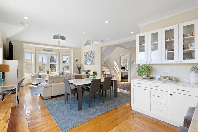 dining space with stairway, light wood-type flooring, lofted ceiling, and recessed lighting