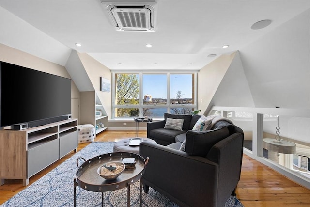 living room featuring light wood finished floors, lofted ceiling, recessed lighting, and baseboards