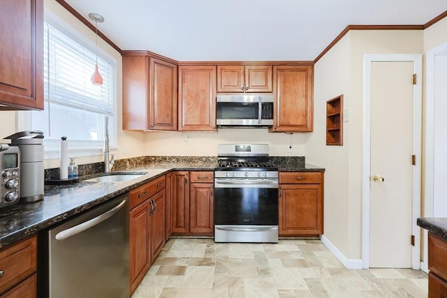 kitchen with dark stone counters, ornamental molding, appliances with stainless steel finishes, and sink