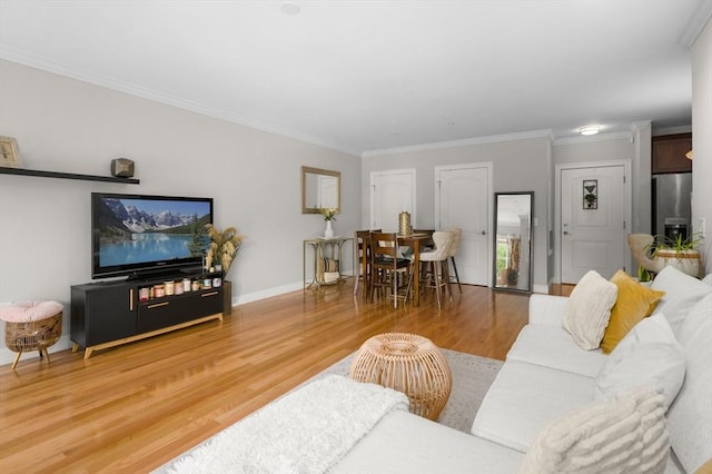 living room featuring wood finished floors, crown molding, and baseboards