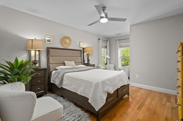 bedroom with light wood finished floors, baseboards, and ceiling fan