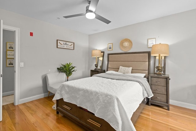 bedroom featuring baseboards, light wood-style floors, and ceiling fan
