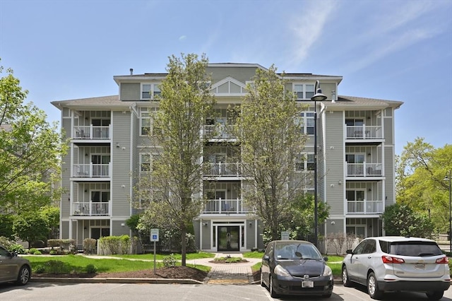 view of apartment building / complex featuring uncovered parking