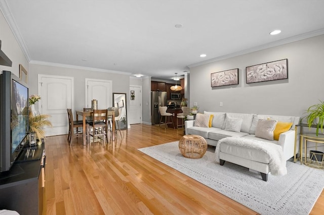 living room with ornamental molding, light wood finished floors, and recessed lighting