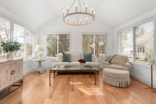 living area with baseboards, lofted ceiling, wood finished floors, and a chandelier