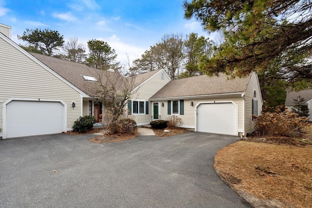 view of front facade featuring aphalt driveway, a shingled roof, and a garage