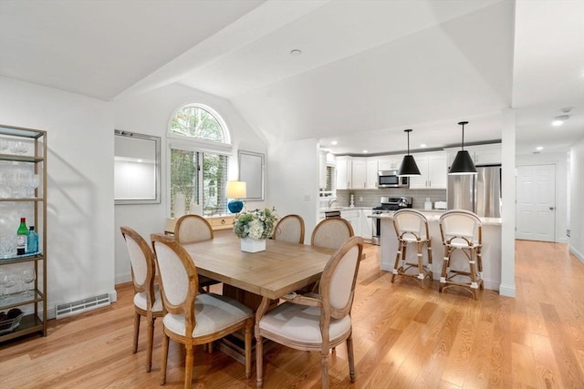 dining area with lofted ceiling, light wood-style floors, visible vents, and baseboards