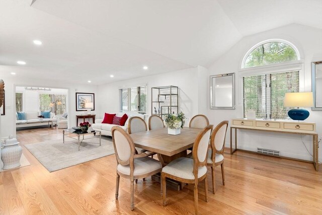 dining area featuring vaulted ceiling, a healthy amount of sunlight, visible vents, and light wood-type flooring