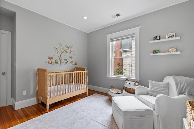 bedroom featuring wood finished floors, baseboards, and recessed lighting
