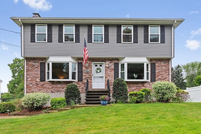 92 Gregory St, Waltham, MA 02451 - colonial house featuring a front lawn and brick siding