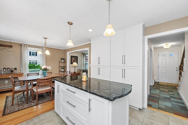 92 Gregory St, Waltham, MA 02451 - kitchen featuring white cabinetry, decorative light fixtures, dark stone countertops, light tile patterned floors, and a kitchen island