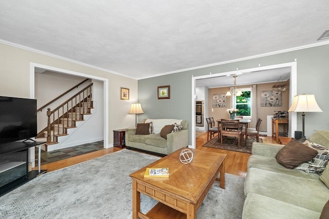 92 Gregory St, Waltham, MA 02451 - living area featuring wood finished floors, crown molding, stairway, and a chandelier