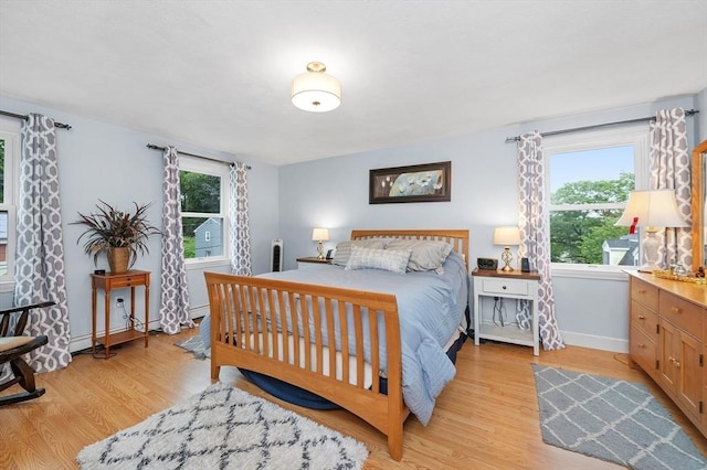 92 Gregory St, Waltham, MA 02451 - bedroom with multiple windows, light wood-type flooring, and baseboard heating