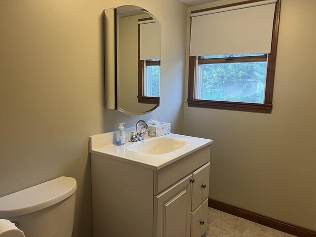 bathroom featuring tile patterned flooring, vanity, and toilet