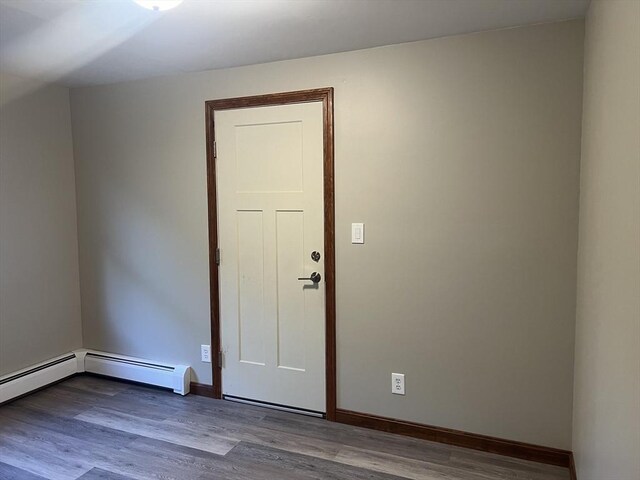 unfurnished room featuring a baseboard radiator and hardwood / wood-style flooring