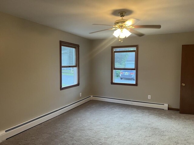 carpeted spare room featuring a baseboard heating unit and ceiling fan