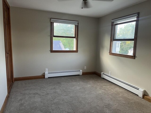 unfurnished bedroom with ceiling fan, baseboard heating, and light carpet