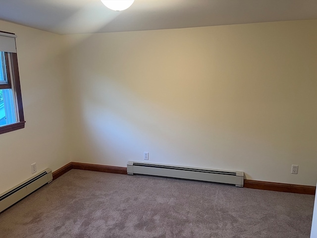 empty room with a baseboard heating unit and carpet