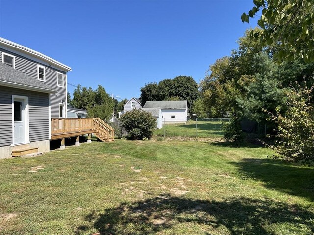 back of property featuring a lawn and a wooden deck