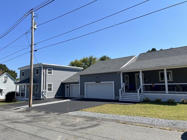 view of front of house featuring a garage, a porch, and a front yard