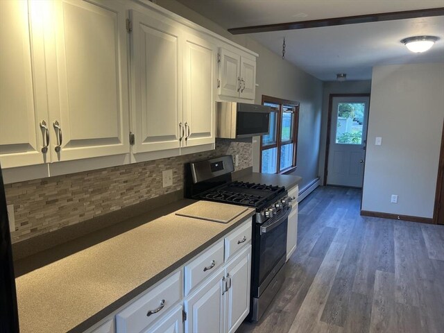 kitchen with white cabinetry, backsplash, stainless steel appliances, wood-type flooring, and a baseboard heating unit