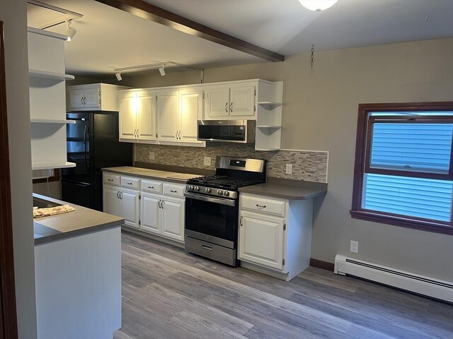 kitchen with appliances with stainless steel finishes, a baseboard radiator, white cabinetry, and light hardwood / wood-style flooring