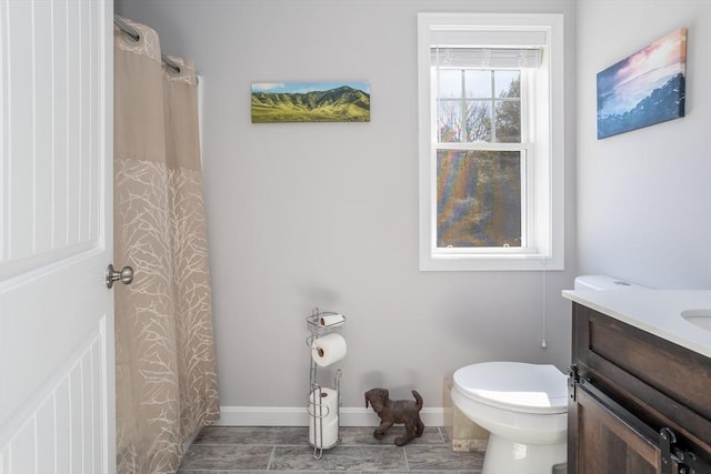 full bath featuring a shower with shower curtain, baseboards, vanity, and toilet