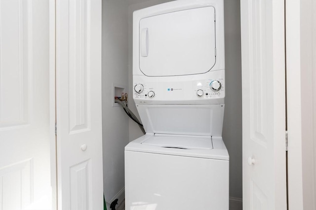 washroom featuring stacked washer and dryer and laundry area