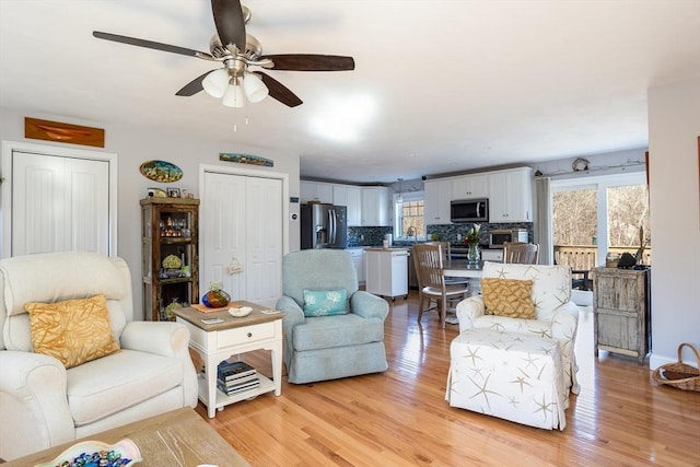 living room featuring light wood-style flooring and a ceiling fan