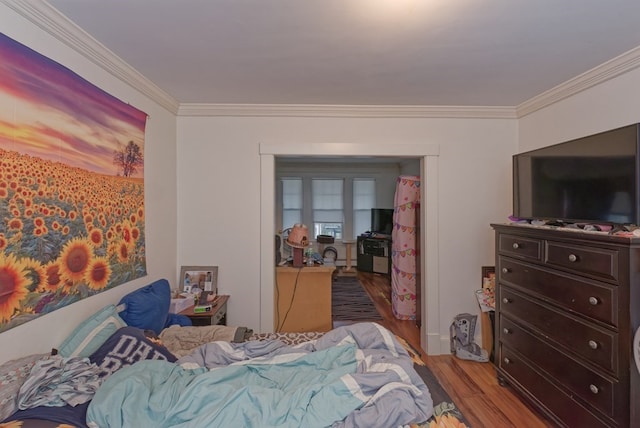 bedroom with crown molding and light hardwood / wood-style flooring