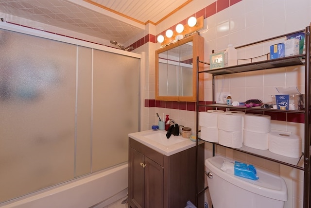 full bathroom with tasteful backsplash, vanity, tile walls, enclosed tub / shower combo, and toilet