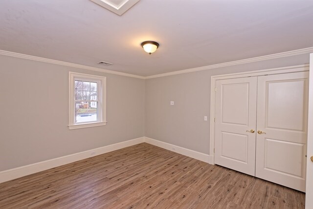 interior space featuring wood-type flooring and crown molding