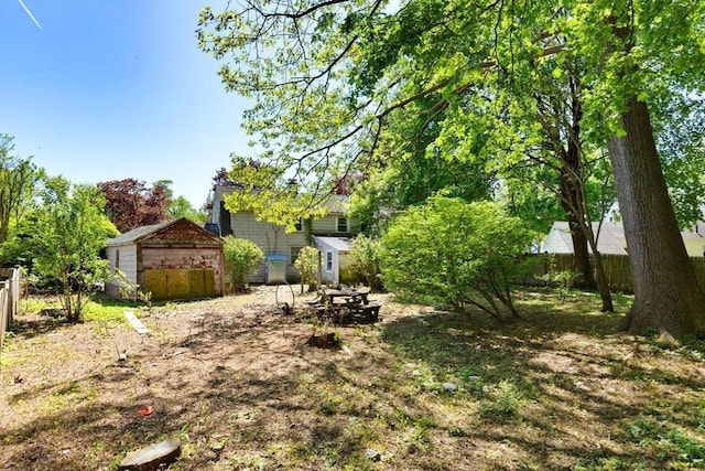 view of yard with fence, a shed, and an outbuilding