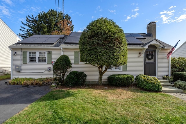 view of front facade with a front lawn and solar panels