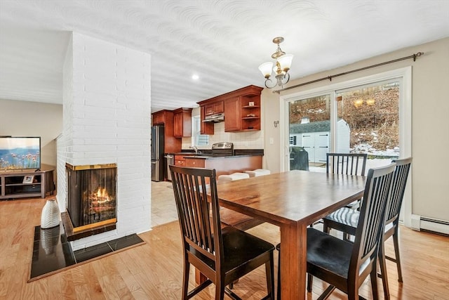 70 Donna Rd, Framingham, MA 01701 - dining space featuring a chandelier, light wood-type flooring, a fireplace, and baseboard heating