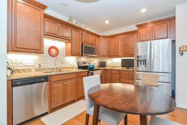62 Abigail Way Unit 2003, Reading, MA 01867 - kitchen with appliances with stainless steel finishes, light wood-style floors, brown cabinetry, light stone countertops, and recessed lighting