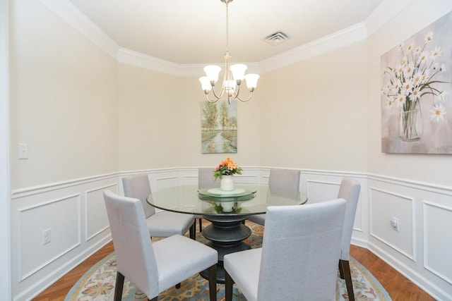 62 Abigail Way Unit 2003, Reading, MA 01867 - dining room with a chandelier, crown molding, wood finished floors, wainscoting, and a decorative wall
