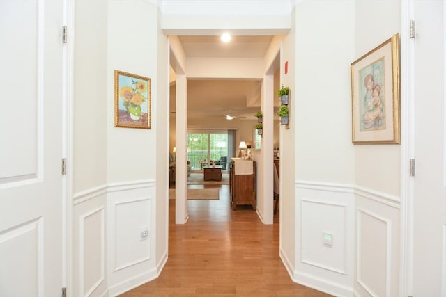 62 Abigail Way Unit 2003, Reading, MA 01867 - corridor featuring a decorative wall, wainscoting, and light wood-style floors