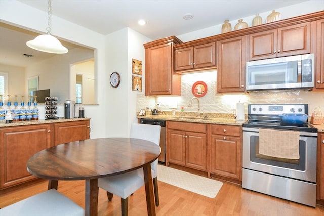 62 Abigail Way Unit 2003, Reading, MA 01867 - kitchen featuring stainless steel appliances, light wood-type flooring, pendant lighting, decorative backsplash, and light stone counters