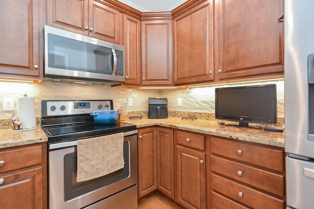 62 Abigail Way Unit 2003, Reading, MA 01867 - kitchen with appliances with stainless steel finishes, backsplash, and brown cabinetry