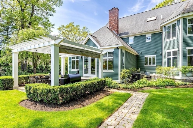 back of property with a yard, a chimney, french doors, and a pergola