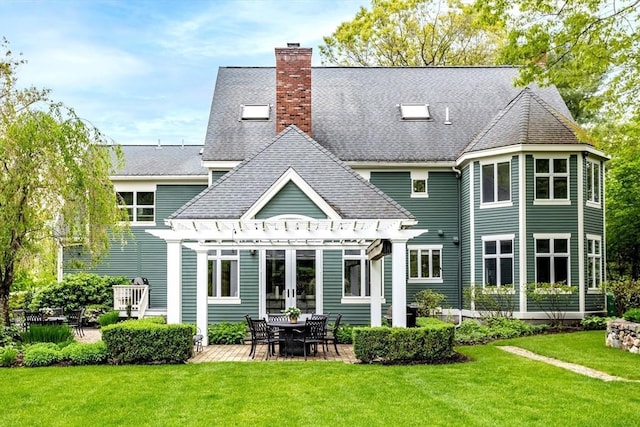 back of property featuring french doors, a yard, a chimney, and a pergola