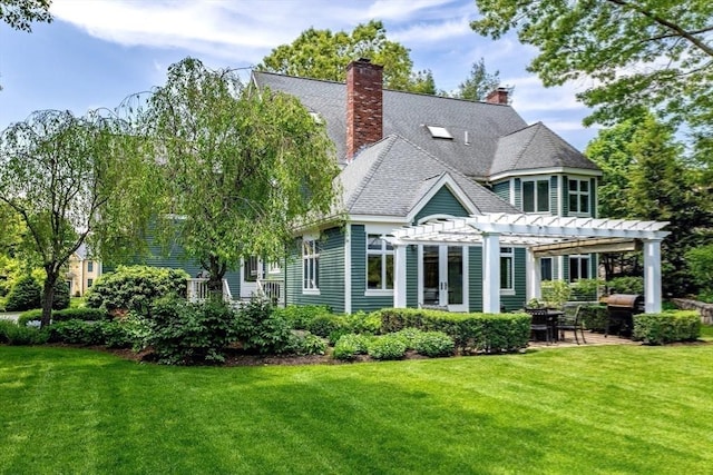 back of property with a pergola, a patio area, and a lawn