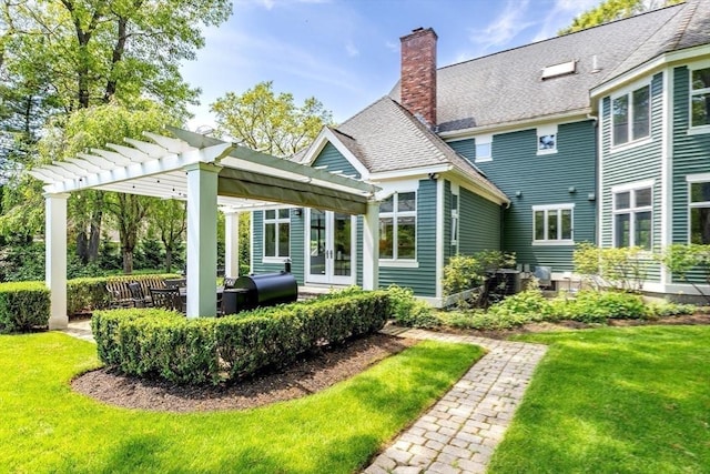 back of property with a lawn, a chimney, french doors, and a pergola