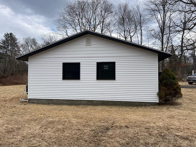 view of side of home with a yard