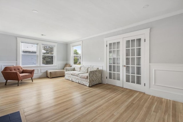 39 Pond St, Framingham, MA 01702 - living room with french doors, wood finished floors, a wainscoted wall, ornamental molding, and a decorative wall