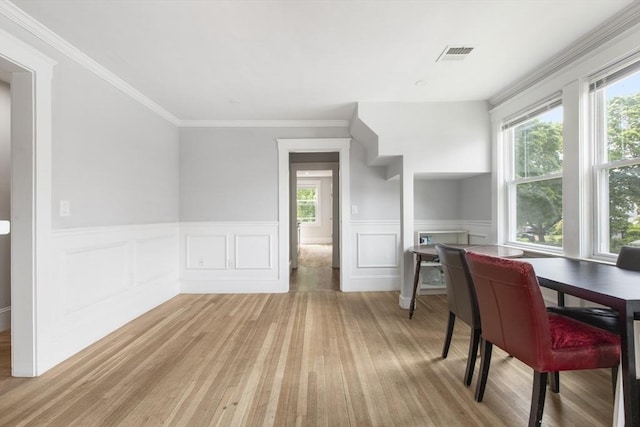 39 Pond St, Framingham, MA 01702 - dining room with wood finished floors, healthy amount of natural light, a wainscoted wall, ornamental molding, and a decorative wall