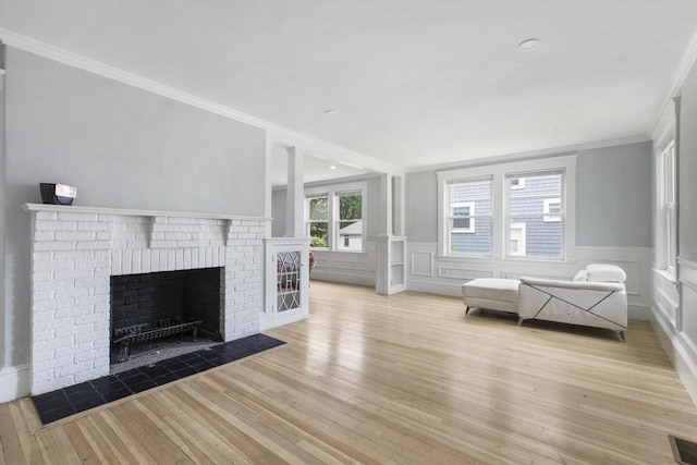 39 Pond St, Framingham, MA 01702 - living area with ornamental molding, wood finished floors, a fireplace, a wainscoted wall, and a decorative wall