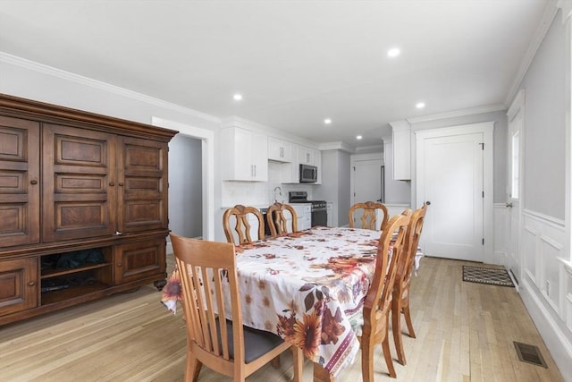 39 Pond St, Framingham, MA 01702 - dining room with light wood-style floors, recessed lighting, crown molding, and a decorative wall