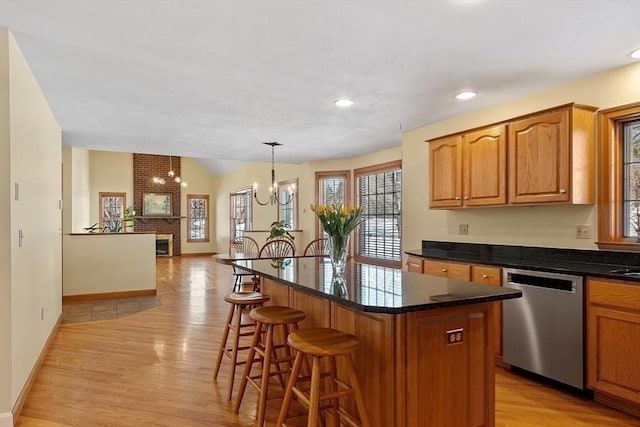 kitchen with open floor plan, a center island, hanging light fixtures, an inviting chandelier, and stainless steel dishwasher